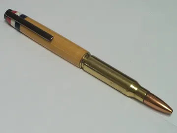 Military rifle cartridge pen in maple with a gun metal clip and Corian flag inlay