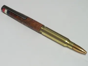 Military rifle cartridge pen in redwood with a gun metal clip and Corian flag inlay