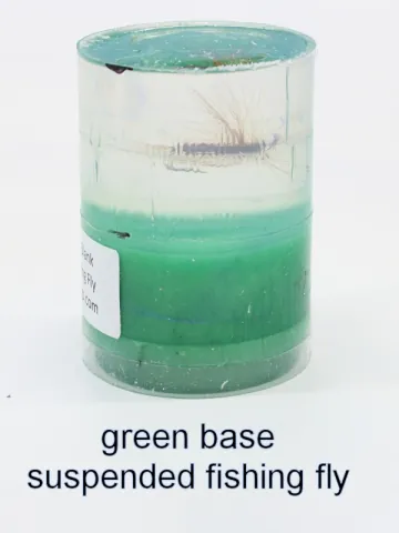 Bottle stopper blank with a suspended fishing fly over a green base