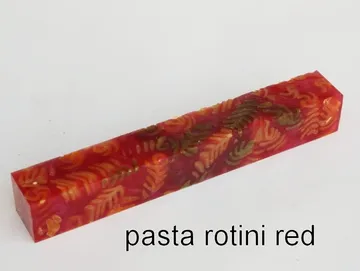 Pen blank of tri-colored rotini pasta suspended in red resin