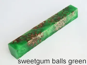 Pen blank of sweet gum balls suspended in green resin